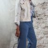 zij aanzicht - Luchtige bloemenblouse in jeansblauw met jeansblauw wijde pantalon en kort wit spijkerjasje, vrouwelijke look met hak.