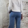 achter aanzicht - Luchtige bloemenblouse in jeansblauw met jeansblauw wijde pantalon en kort wit spijkerjasje, vrouwelijke look met hak.