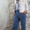 Luchtige bloemenblouse in jeansblauw met jeansblauw wijde pantalon en kort wit spijkerjasje, vrouwelijke look met hak.