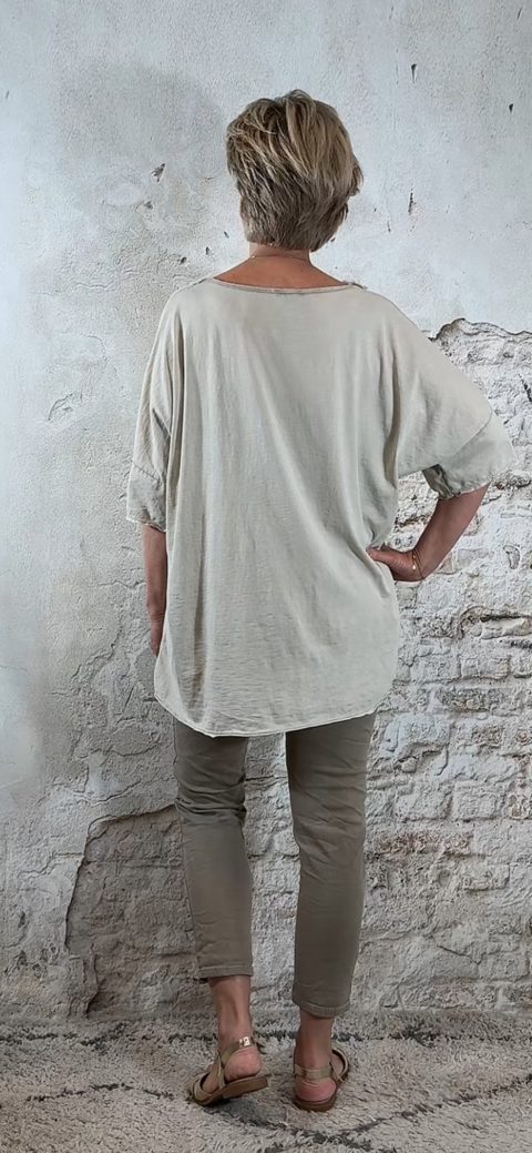 Nancy toont de achterkant van het shirt, vallend over de heupen.
