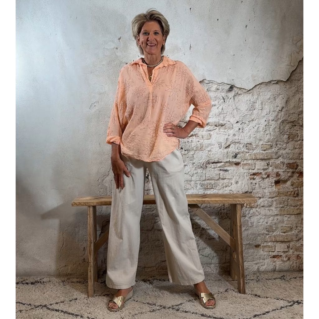 katoenen licht oranje blouse met Ibiza zonnen en een tikkie gouden glitters met een linnen broek in zandkleur