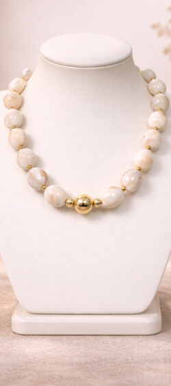 grote kralenketting kort model met gemarmerde afgeronde hartvormige kralen, er is een bijpassende armband van