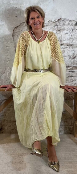 Zijden blouse lichtgeel met kanten mouwen gecombineerd met lichtgele katoenen crinkle rok en elastische riem en pumps in goudkleur