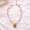 Roze korte halsketting met grote kralen in de vorm van hartjes en een gouden hart in het midden. Chunky hearts ketting Baboux